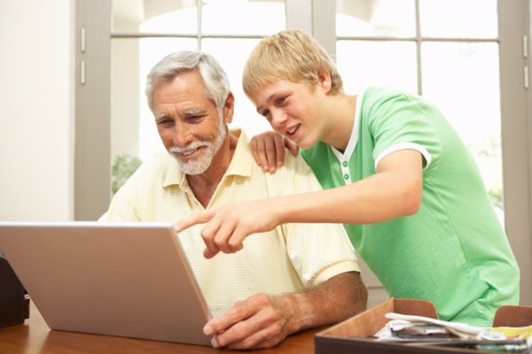 Abuelo y nieto compartiendo un ordenador