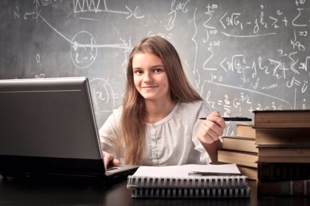 Adolescente aprende la tabla periódica con ordenador, estudio